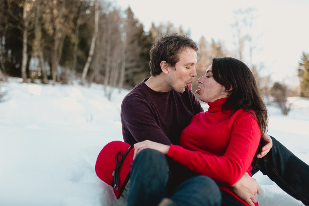 Destination session - Casal estirando língua durante ensaio na neve nos Alpes Suíços