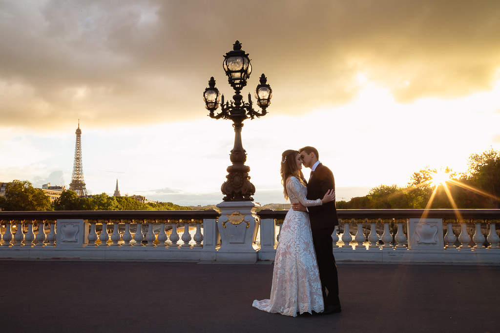 Elopement Wedding photographer - Couple kissing with a stunning sunset at Alexander III Bridge