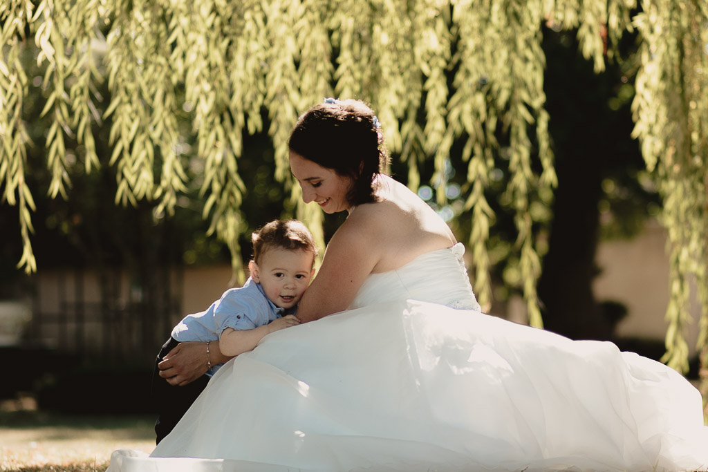 La mariée et son bébé sourient le jour de son mariage