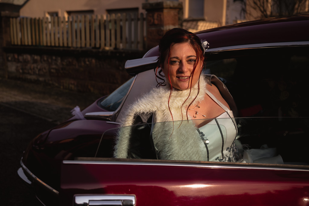La mariée rentre dans la voiture - Mariage d'hiver