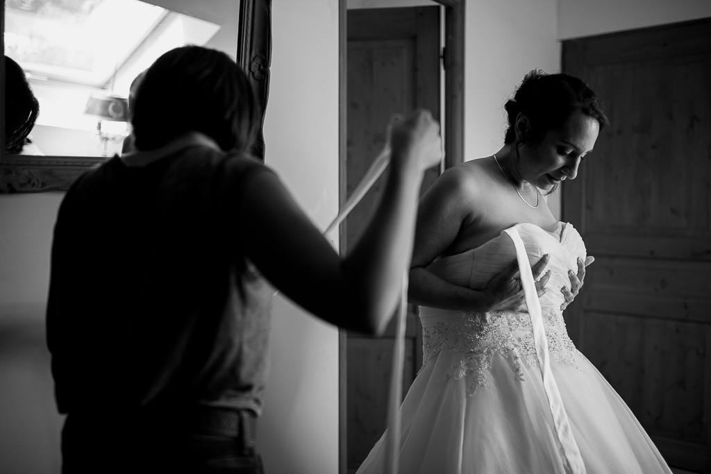 la mariée s'habille avec l'aide de sa soeur et témoin