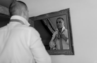 le marié fait son noeud de cravate