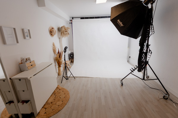 Intérieur cosy et chaleureux du studio photo à Saint-Maur-des-Fossés, éclairé par spots, flashs et LED, espace modulable pour séances grossesse, famille et nouveau-né.
