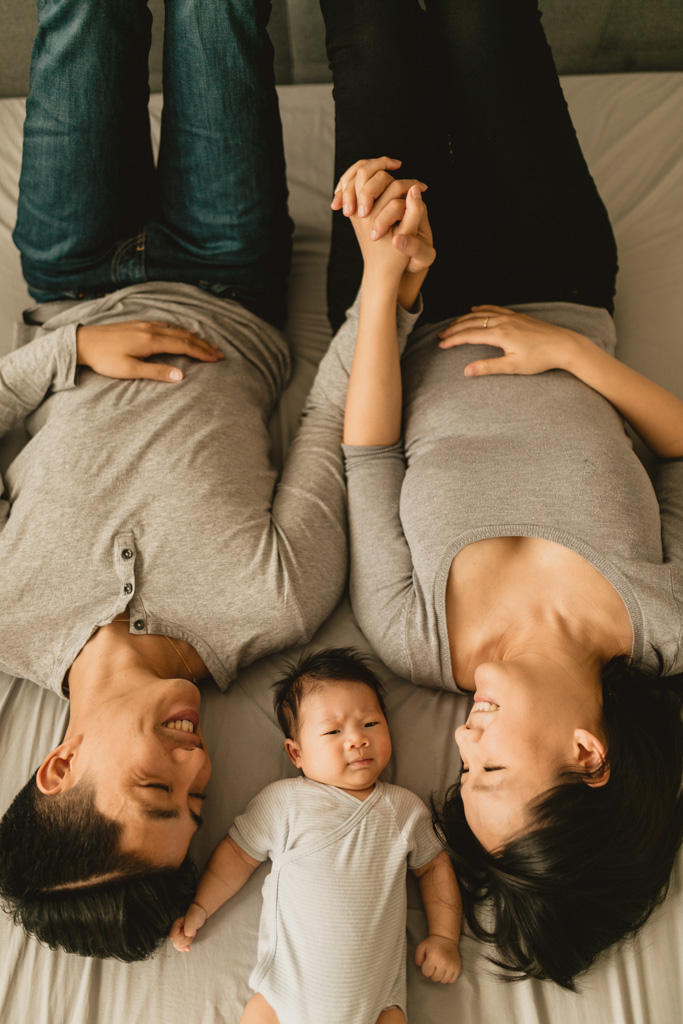 Parents allongés au lit avec bébé d’un mois à Paris