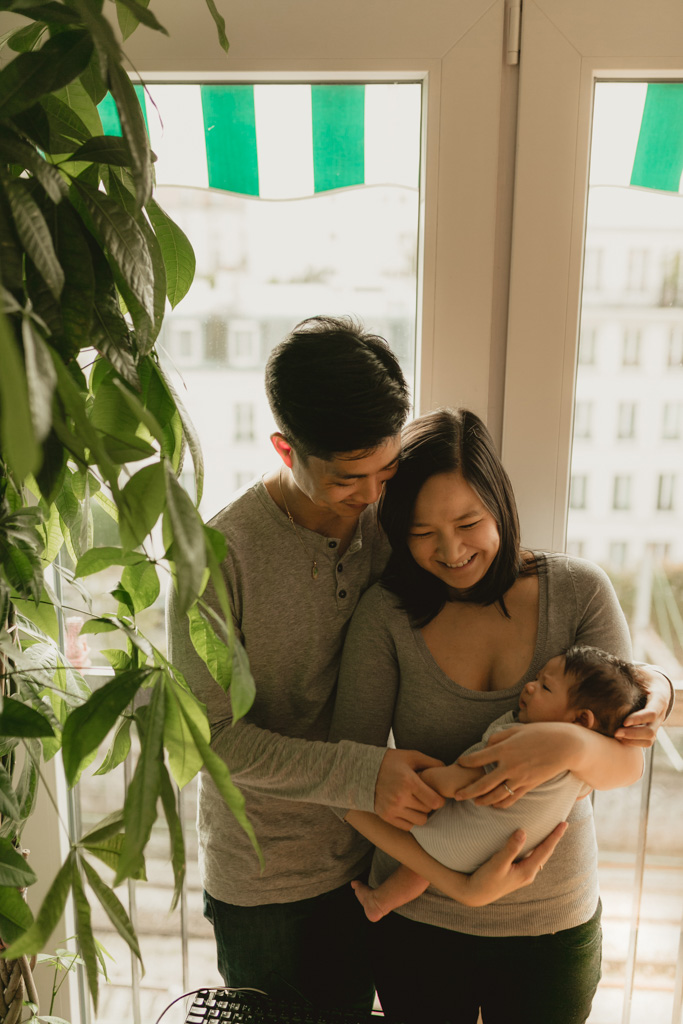 Parents tenant bébé dans leurs bras au salon à Vincennes