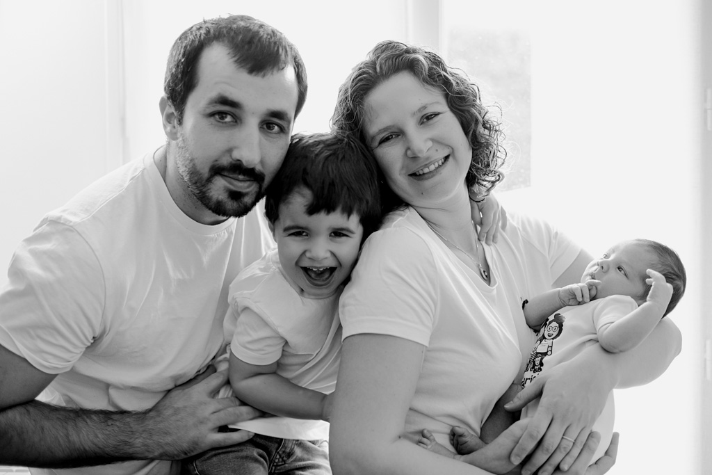 Photo de famille avec parents, nouveau-né et aîné souriant, séance à domicile Saint-Maur, photographe naissance