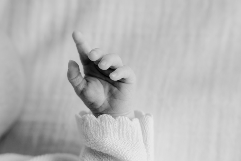 Photo naissance macro à domicile : main du nouveau-né capturée avec tendresse, séance naissance à Paris
