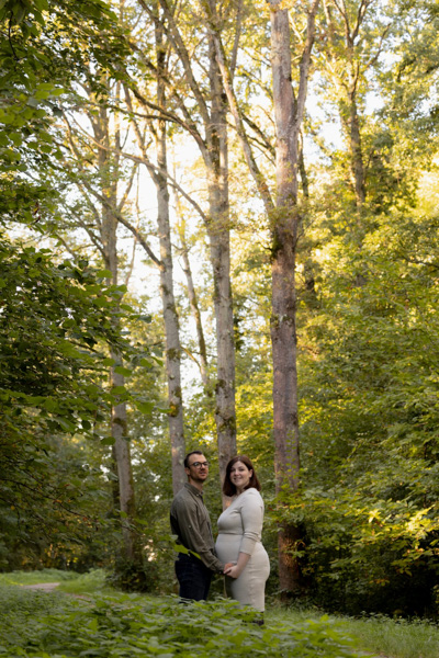 Couple en forêt lors d’une mini séance grossesse automnale, moment tendre en pleine nature