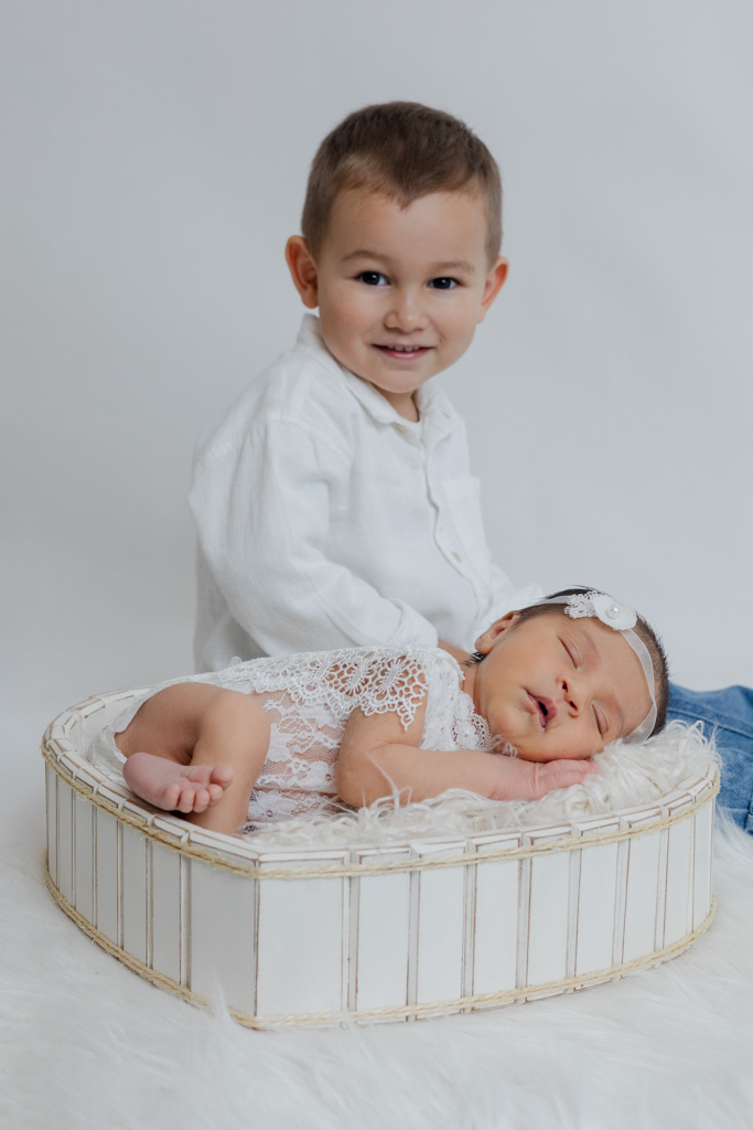 Photo de nouveau-né avec son frère aîné lors d’une séance naissance en studio à Saint-Maur.