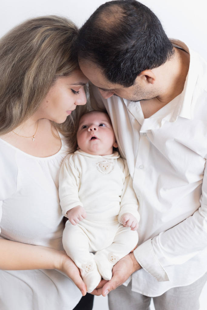 Parents regardant bébé au milieu d’eux