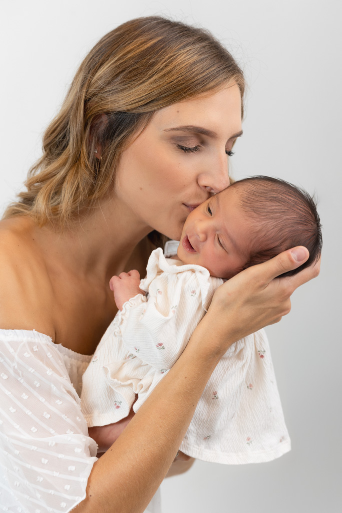 Nouveau-né fille avec maman qui lui fait un bisou en studio Saint-Maur