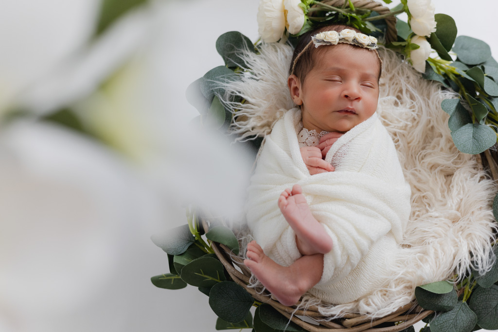 Nouveau-né fille emmaillotée dans panier fleuri, studio Val-de-Marne