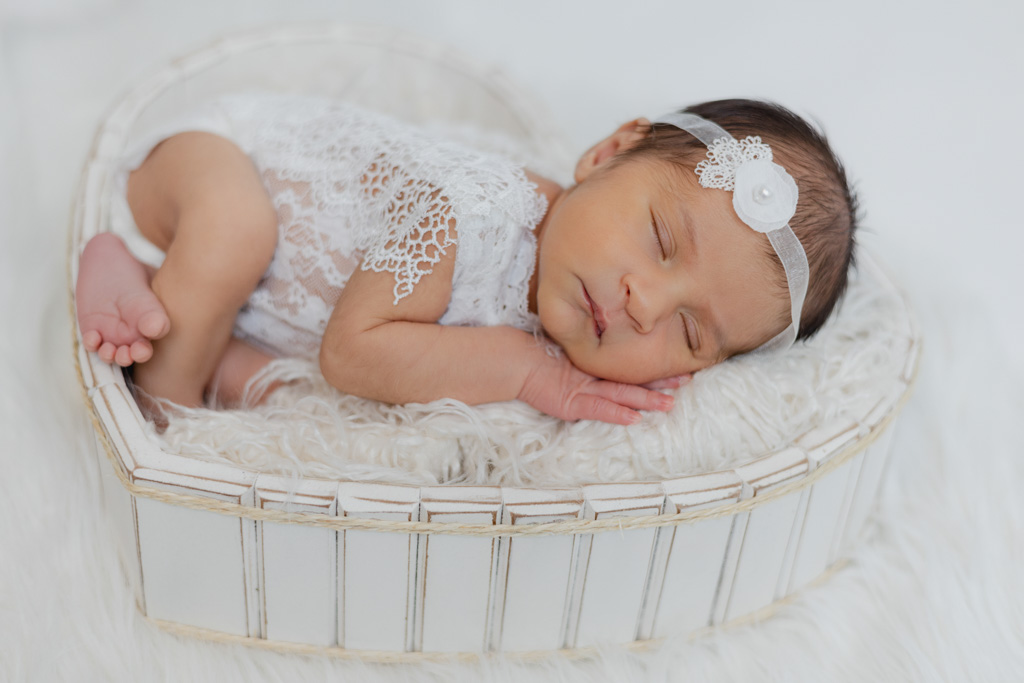 Nouveau-né emmailloté dans un panier décor minimaliste en studio à Saint-Maur.