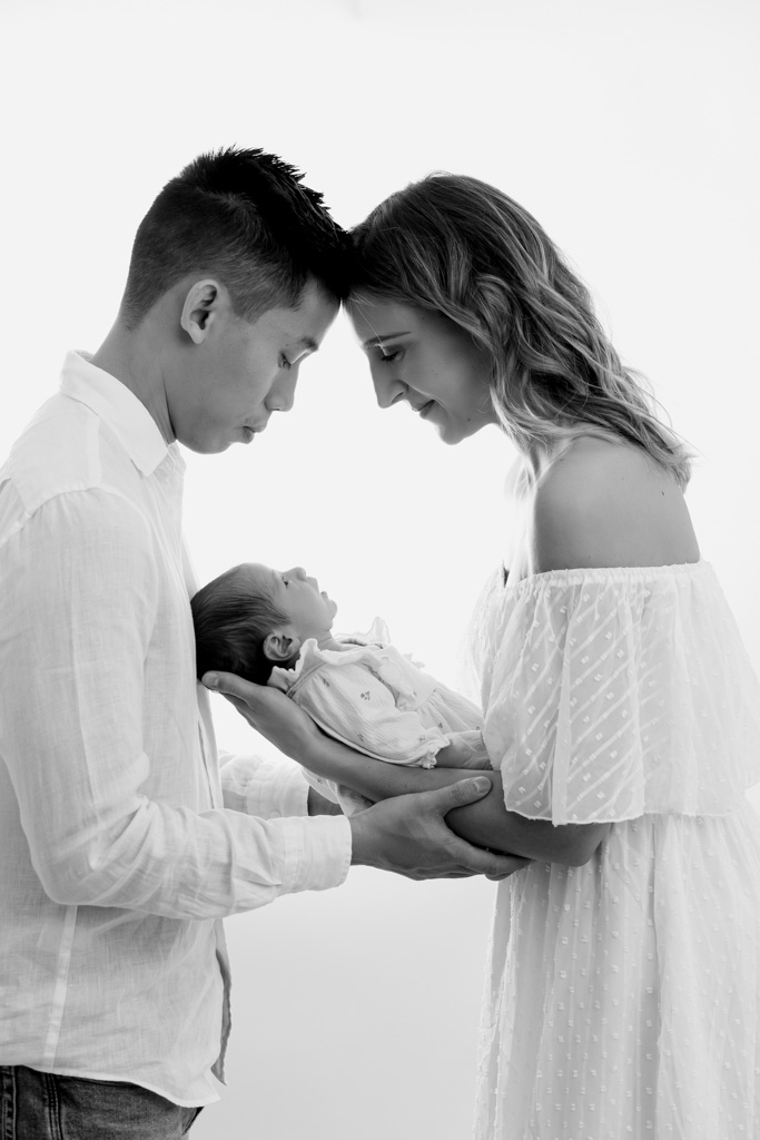 Nouveau-né dans les bras de ses parents en studio à Saint-Maur